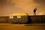 Man Standing on Wall Near Camper at Dusk, London, UK