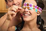 Man Feeding Blindfolded Woman a Cherry