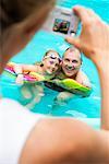 Femme prise de photo du père et fille dans la piscine