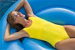 Woman Floating in Swimming Pool