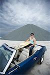 Portrait of Young Man Holding Surfboard, Sitting in Convertible