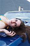 Portrait of Woman Lying on Hood of Car