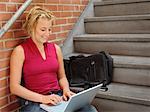 Student mit Laptop-Computer, die sitzt auf der Treppe