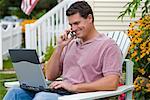 Man Using Laptop and Cell Phone Outdoors