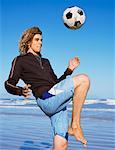 Man Playing with Soccer Ball on Beach