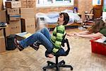 Woman Pushing Man in Office Chair