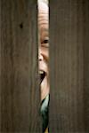 Man Peeking Through Fence