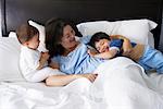 Mother and Children Playing in Bed