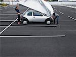 Couple in Parking Lot, Lifting Cover off Car