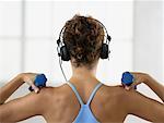 Woman Wearing Headphones and Lifting Weights