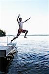 Boy Jumping off Dock into Lake