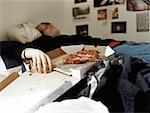 Boy sleeping with pizza on bed