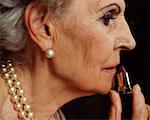Senior woman applying lipstick