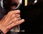 Close up of a senior woman holding a pearl bracelet