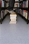 Person standing on books in library