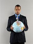 Portrait of Businessman Holding Globe