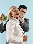 Businessman Feeding Grapes to Businesswoman