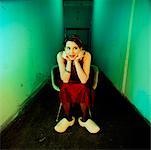 Woman Sitting in Run Down Hallway