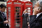 Geschäftsleute, die über Mobiltelefone, London, England