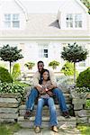 Homme et femme assise sur les marches devant la maison