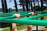 Person hanging onto monkey bars