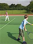 Brother and sister playing tennis