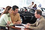 Couple Speaking with Car Salesman