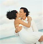 Braut und Bräutigam küssen am Strand