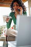 Woman Using Credit Card over Telephone