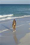 Femme qui marche le long de la plage à Cuba