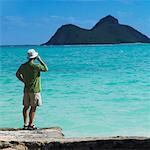 Homme debout sur le rocher de l'océan, parler au téléphone cellulaire, Oahu, Hawaii