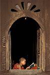 Étudiant bouddhiste dans la fenêtre du monastère, près du lac Inle, Myanmar