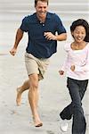 Vater und Tochter am Strand laufen