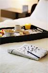 Newspaper and Breakfast Tray on Hotel Bed