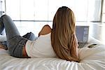Femme au lit, en utilisant un ordinateur portable