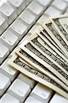 United States one hundred dollar bills on top of computer keyboard close-up