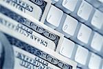 United States one hundred dollar bills on top of computer keyboard close-up