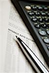 Calculatrice scientifique, stylo et liste des taux d'intérêt, gros plan