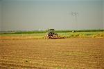 Tracteur labourant une ferme