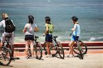 Rear view of a group of cyclists looking at the Ocean