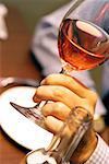 Close-up of a person's hand holding a glass of wine