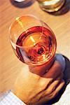 Vue de la forte inclinaison de la main d'une personne tenant un verre de vin