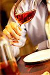 Close-up of a person's hand holding a glass of wine