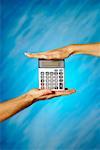 Close-up of a man and a woman's hands holding a calculator