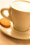 Close-up of a cup of coffee served with a cookie