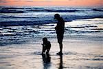 Père et sa fille jouent dans l'eau à la plage