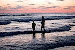 Father and his daughter standing in the water at the beach