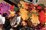 High angle view of a senior man and a mid adult man standing near a cart loaded with clothes