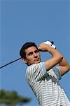 Portrait d'un homme faisant un swing de golf