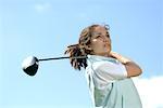 Portrait d'une jeune femme tenant un bâton de golf